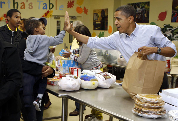 US President Barack Obama and his family hand out food while visiting Martha&apos;s Table food pantry in Washington, Nov 24, 2010. [China Daily/Agencies]