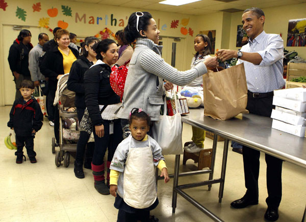 US President Barack Obama and his family hand out food while visiting Martha&apos;s Table food pantry in Washington, Nov 24, 2010. [China Daily/Agencies]