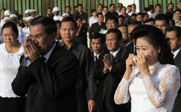 Cambodia&apos;s Prime Minister Hun Sen and wife Bun Rany pay their respects to the 456 people killed in a stampede on a bridge on Nov 22, during a ceremony on a national day of mourning in Phnom Penh Nov 25, 2010. [China Daily/Agencies]