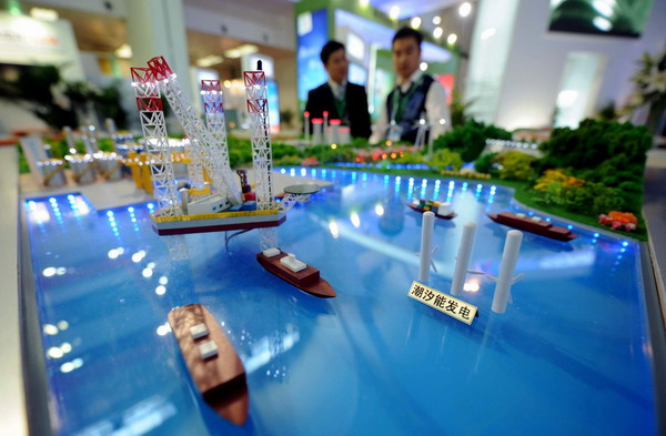 Visitors watch models of power generation projects using tidal waves at the clean energy pavilion of the China International Green Industry Expo 2010 at Beijing Exhibition Center in Beijing, Nov 24, 2010. [Xinhua]