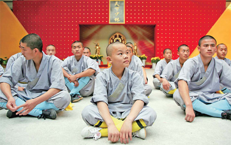 Huang Liang (center), 13, sits with other wushu trainees during a break from practicing a routine at Shaolin Temple Martial Arts School in the city of Dengfeng. Most students said they hope to become coaches after graduating. 