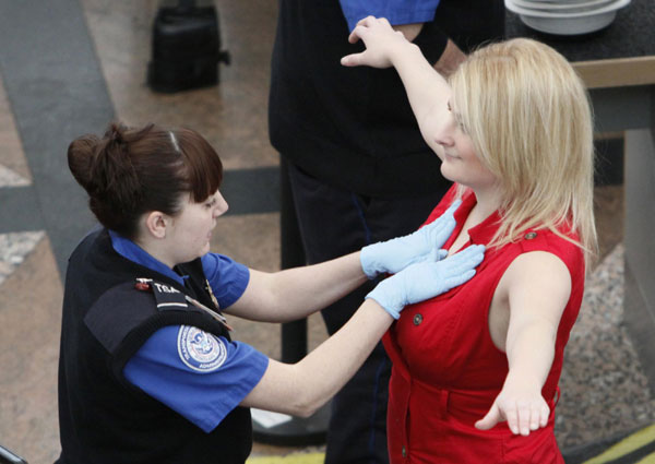 A Transportation Security Agency (TSA) worker (L) runs her palms across a traveler&apos;s chest during a patdown search at Denver International Airport, the day before the Thanksgiving holiday, in Denver Nov 24, 2010.