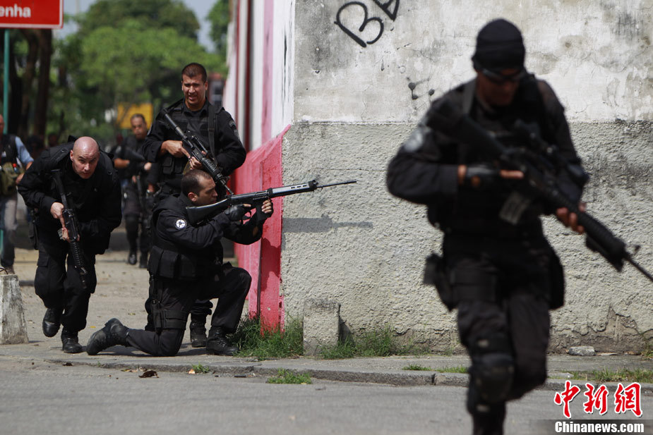 Policemen run during a shootout with traffickers during an operation at Vila Cruzeiro slum in Rio de Janeiro November 25, 2010. 