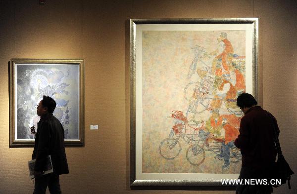 Visitors look at paintings at an exhibition of heavy color ink painting in Beijing, capital of China, Nov. 25, 2010. The exhibition, cosponsored by China's art and painting institutions, displayed works of 87 Chinese painters. 
