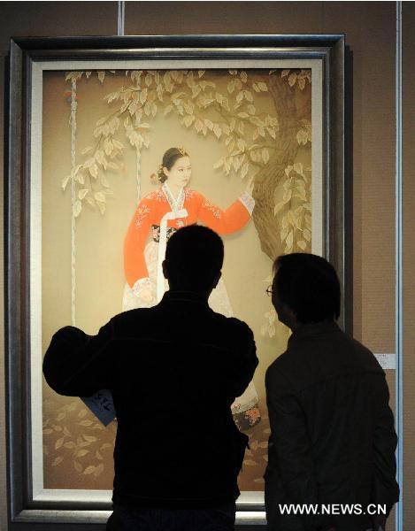 Visitors look at a painting at an exhibition of heavy color ink painting in Beijing, capital of China, Nov. 25, 2010. The exhibition, cosponsored by China's art and painting institutions, displayed works of 87 Chinese painters. 
