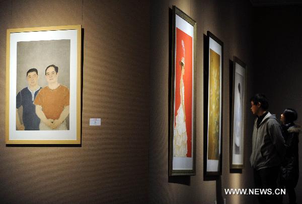 Visitors look at paintings at an exhibition of heavy color ink painting in Beijing, capital of China, Nov. 25, 2010. The exhibition, cosponsored by China's art and painting institutions, displayed works of 87 Chinese painters. 