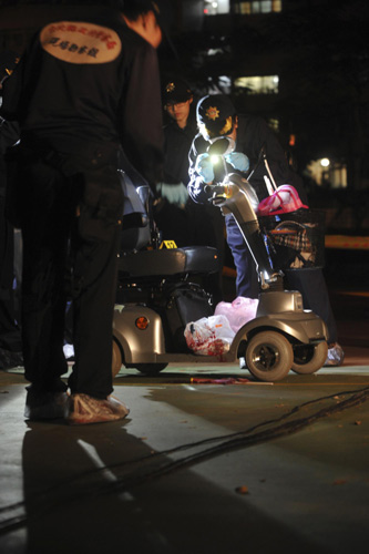 Police officials inspect the scene where Sean Lien, the son of KMT honorary chairman Lien Chan, was shot in the face while speaking at a campaign rally in Taipei, Nov 26, 2010. [Xinhua]