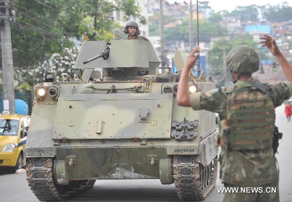 A tank moves in the street of Vila Cruzeiro, north of Rio de Janeiro, Brazil, Nov. 26, 2010. Some 800 soldiers and police with tanks carried out the operation against heavily-armed gangsters to control the worsened situation. [Song Weiwei/Xinhua]