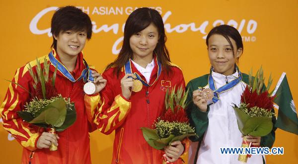 China's He Zi (C), Shi Tingmao (L) and Choi Sut Ian of Macao of China pose on the podium of the women's 3m springboard final of Diving event at the 16th Asian Games in Guangzhou, south China's Guangdong Province, Nov. 26, 2010. He Zi won the gold medal with 382.00 points, while Shi Tingmao and Choi Sut Ian got the silver and bronze medal respectively. (Xinhua/Fei Maohua)