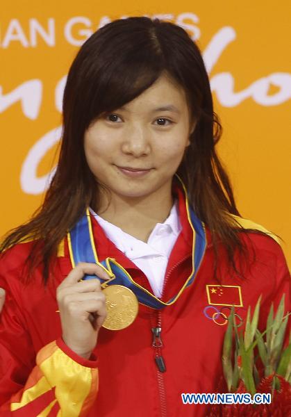 China's He Zi stands on the podium of the women's 3m springboard final of Diving event at the 16th Asian Games in Guangzhou, south China's Guangdong Province, Nov. 26, 2010. He Zi won the gold medal with 382.00 points. (Xinhua/Fei Maohua)