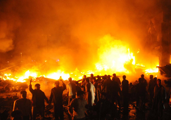Pakistani volunteers struggle to extinguish the fire at the site of a plane crash in southern Pakistani port city of Karachi on Nov. 28, 2010. At least 18 people including 10 on the ground were killed as a Russian-made IL 76 cargo plane crashed in a residential area near the Karachi airport in southern Pakistan early Sunday morning. [Xinhua]