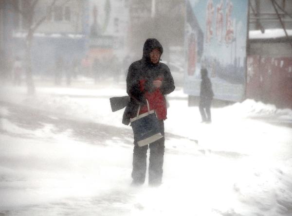 People walk against strong wind in Jilin City, northeast China&apos;s Jilin Province, Nov. 27, 2010. Snowfall hit most parts of the province from Friday night. Local meteorologic authority has issued a blue alarm against cold wave Saturday morning.[Xinhua] 