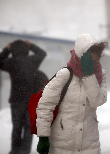 People walk against strong wind in Jilin City, northeast China&apos;s Jilin Province, Nov. 27, 2010. Snowfall hit most parts of the province from Friday night. Local meteorologic authority has issued a blue alarm against cold wave Saturday morning. [Xinhua]