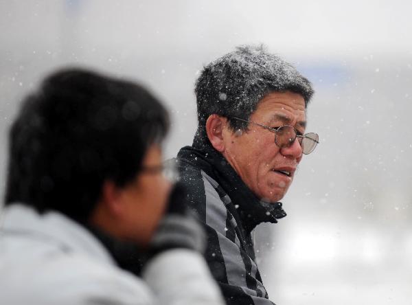 People are seen in snow in Changchun, capital of northeast China&apos;s Jilin Province, Nov. 27, 2010. Snowfall hit most parts of the province on Saturday with temperature drop of up to 9 degrees centigrade.[Xinhua]