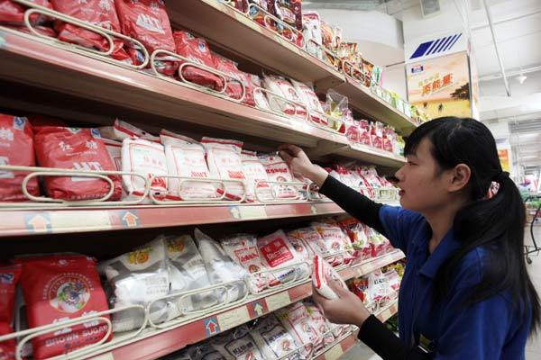 An employee puts bags of sugar on to shelves at a supermarket in Beijing. The price of the commodity has doubled in China since the beginning of the year. (Photo: China Daily)