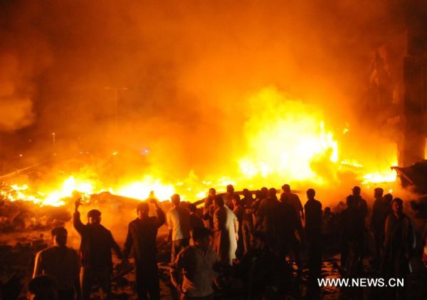 Pakistani volunteers struggle to extinguish the fire at the site of a plane crash in southern Pakistani port city of Karachi on Nov. 28, 2010. [Xinhua]