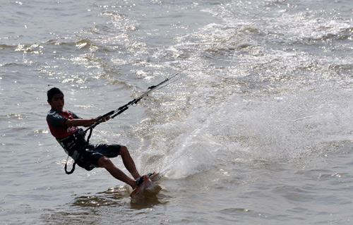 Kite surfers ride the waves in S China