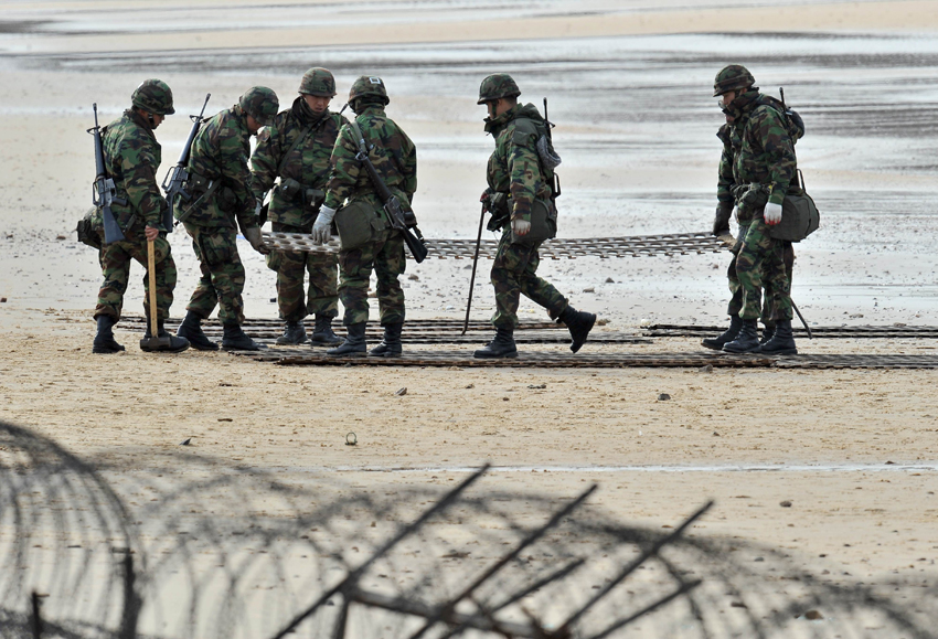 South Korean army soldiers take part in an exercise before a marines landing drill at Mallipo beach in Taean, about 170km (106 miles) southwest of Seoul, November 28, 2010. [Xinhua]