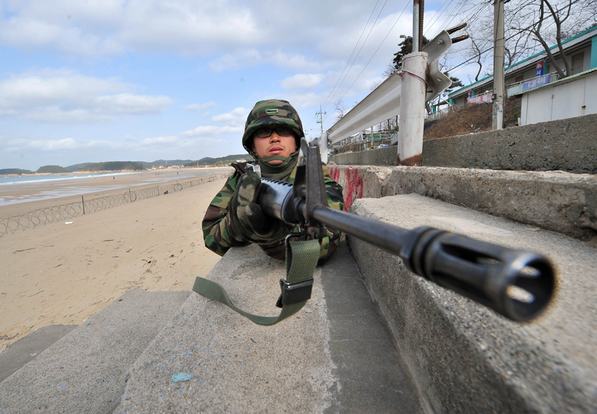 South Korean army soldiers take part in an exercise before a marines landing drill at Mallipo beach in Taean, about 170km (106 miles) southwest of Seoul, November 28, 2010. [Xinhua]