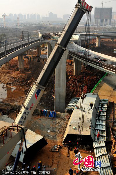 Workers on Saturday clear up the site of a construction accident in Nanjing, Jiangsu province, in which seven were killed when steel box girders for a bridge toppled over. [CFP] 