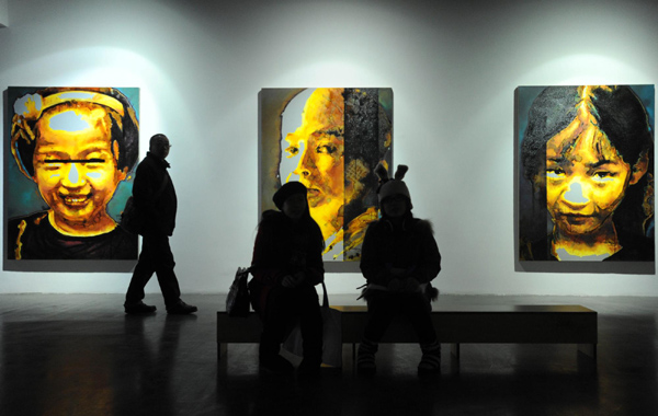 People gaze at an art exhibition in Beijing showing the life of HIV carriers in rural areas of China, Nov 28, Beijing.