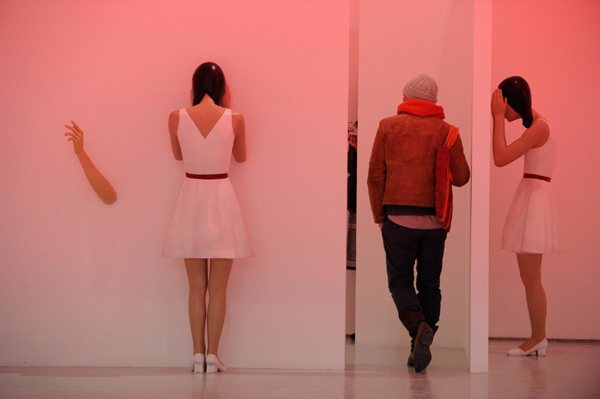 A visitor looks at an installation artwork during the exhibition, Nov 28, Beijing. [Xinhua]