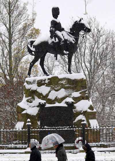 Pedestrians pass a statue on Princes Street in Edinburgh, Scotland November 28, 2010. Freezing temperatures were recorded around the country after heavy overnight snowfalls, local media reported. [Xinhua/Reuters]