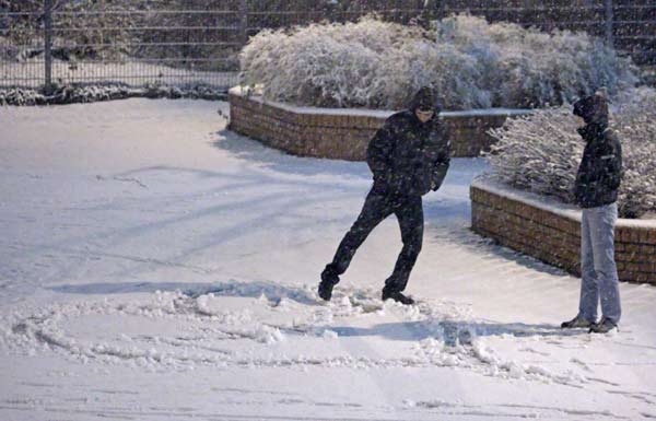 A couple draws a heart into the snow during the first snowfall of this season in Vienna, November 28, 2010. [Xinhua/Reuters]