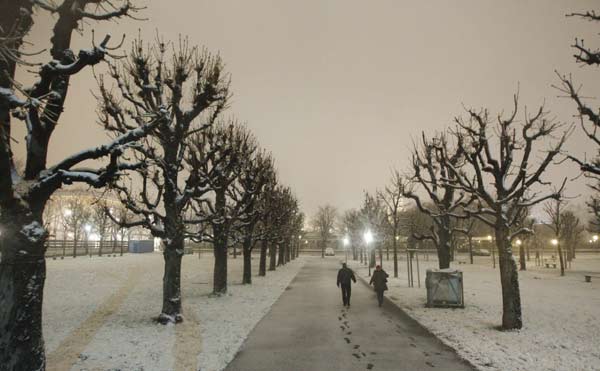 A couple cross the snow covered Heldenplatz (Heroes&apos; square) during the first snowfall of this season in Vienna November 28, 2010. [Xinhua/Reuters] 