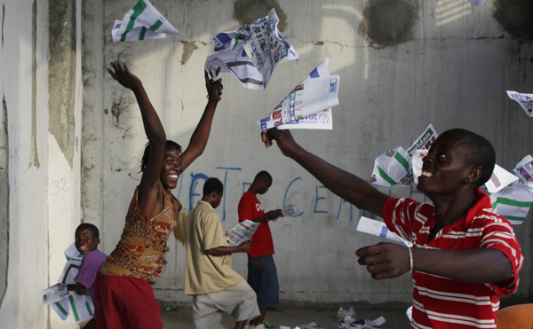 Haitians throw ballots into the air after frustrated voters destroy electoral material during a protest in a voting center in Port-au-Prince November 28, 2010. [Xinhua]