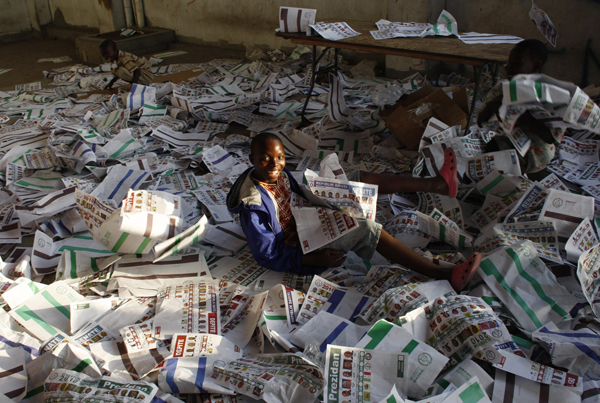 Haitian child plays with ballots after frustrated voters destroy electoral material during a protest in a voting center in Port-au-Prince November 28, 2010. [Xinhua]