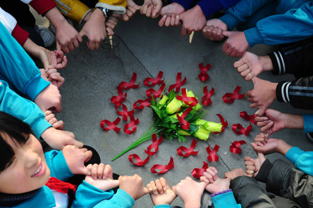 Primary school students in Nanyang, Henan Province, agree to help fight against the spread of AIDS during a meeting Saturday with five orphans whose parents died from the disease. 