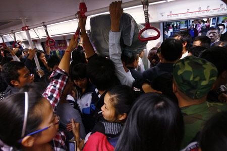 On the first day of free subway service on November 1 in Guangzhou, Guangdong Province, thousands crowded a train. Experts said poor planning in some cities have lead to poor utilization of trains.