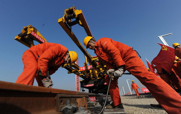 Workers lay down tracks for the 840 km Shijiazhuang-Wuhan high speed rail in Xuchang, Central China&apos;s Henan province, Nov 29, 2010. [Xinhua]