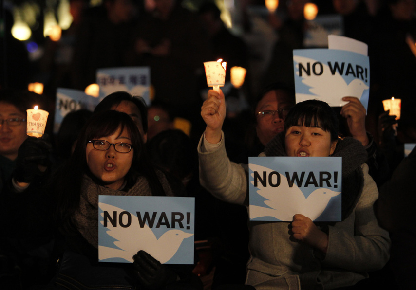 People hold candles to express their wish of peace during a rally against the joint military exercise of South Korea and the United States in Seoul, capital of South Korea, on Nov. 29, 2010. [Xinhua]