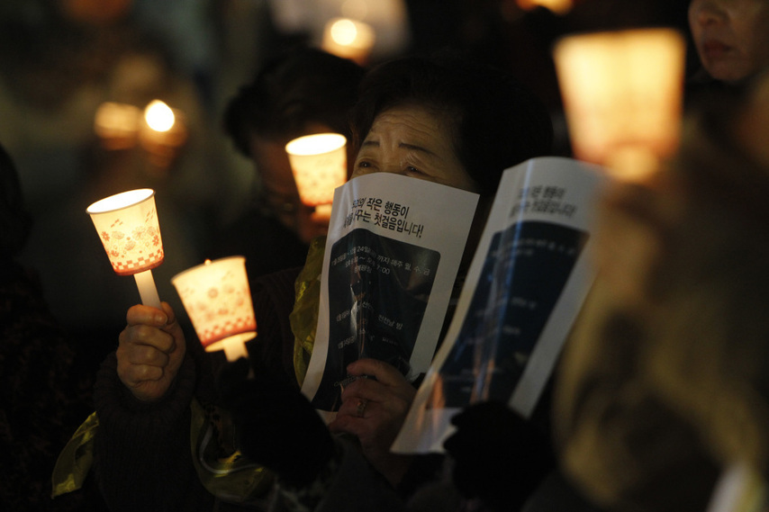 People hold candles to express their wish of peace during a rally against the joint military exercise of South Korea and the United States in Seoul, capital of South Korea, on Nov. 29, 2010. [Xinhua]