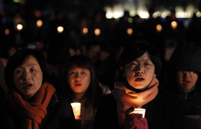 People hold candles to express their wish of peace during a rally against the joint military exercise of South Korea and the United States in Seoul, capital of South Korea, on Nov. 29, 2010. [Xinhua]