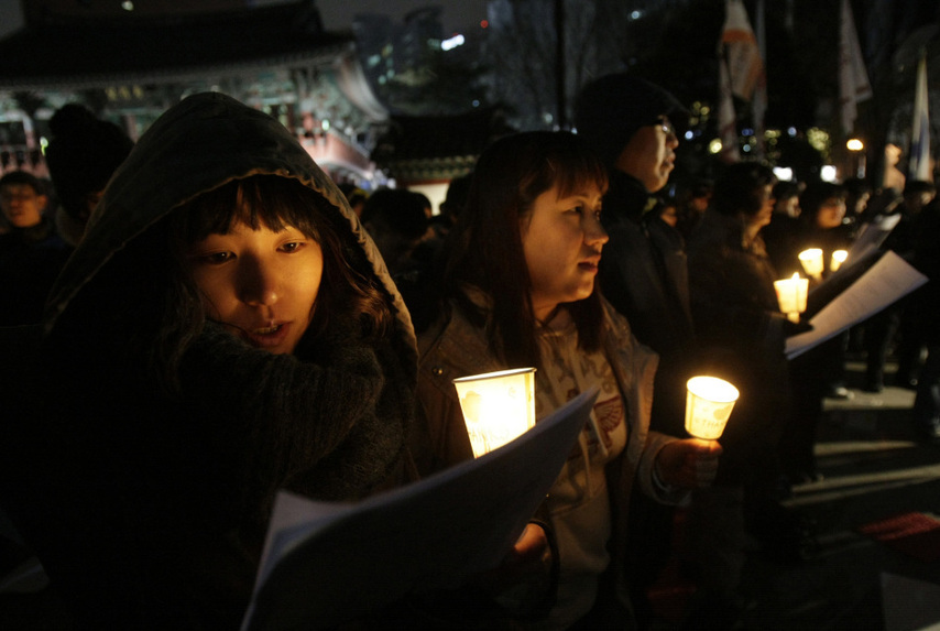 People hold candles to express their wish of peace during a rally against the joint military exercise of South Korea and the United States in Seoul, capital of South Korea, on Nov. 29, 2010. [Xinhua]