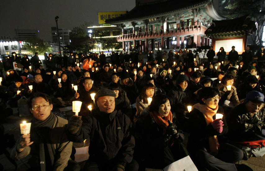 People hold candles to express their wish of peace during a rally against the joint military exercise of South Korea and the United States in Seoul, capital of South Korea, on Nov. 29, 2010. [Xinhua]