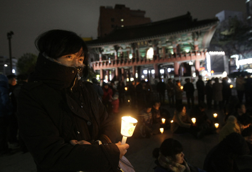 People hold candles to express their wish of peace during a rally against the joint military exercise of South Korea and the United States in Seoul, capital of South Korea, on Nov. 29, 2010. [Xinhua]