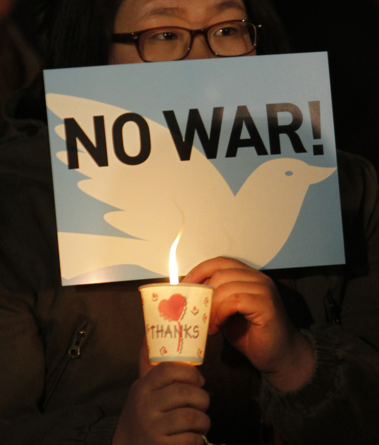 People hold candles to express their wish of peace during a rally against the joint military exercise of South Korea and the United States in Seoul, capital of South Korea, on Nov. 29, 2010. [Xinhua]