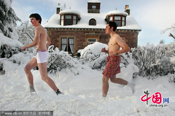 Two young men joke around in the snow on November 29, 2010 in Auchterarder, Scotland. [CFP]