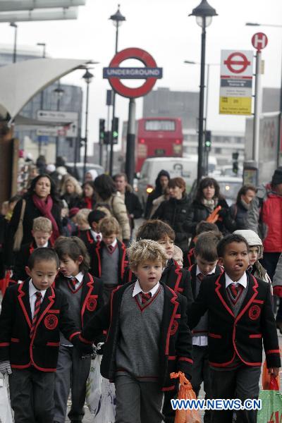 Children walk past a sign of tube station in London, capital of Britain, Nov. 29, 2010. Passengers on the London Underground network are enduring disruption to their journeys as thousands of members of the Transport Salaried Staffs Association (TSSA) and the Rail, Maritime and Transport Union (RMT) stage a 24-hour strike to protest planned job cuts from Sunday evening, the fourth 24-hour strike on London tube system since August. [Bimal Gautam/Xinhua]