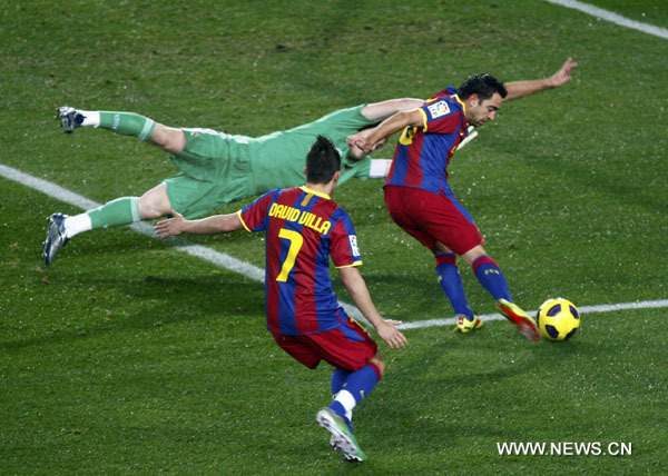 Barcelona's Xavi (R) shoots but fails to score past Real Madrid's goalkeeper Iker Casillas as Barcelona's David Villa looks on during their Spanish first division soccer match at Nou Camp stadium in Barcelona November 29, 2010. (Xinhua/Reuters Photo)