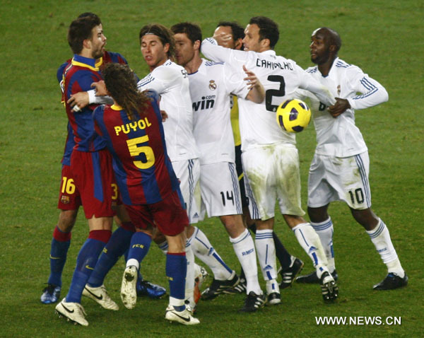 Real Madrid's Sergio Ramos (3rd L) pushes Barcelona's Carles Puyol (2nd L) during their Spanish first division soccer match at Nou Camp stadium in Barcelona, November 29, 2010. (Xinhua/Reuters Photo)