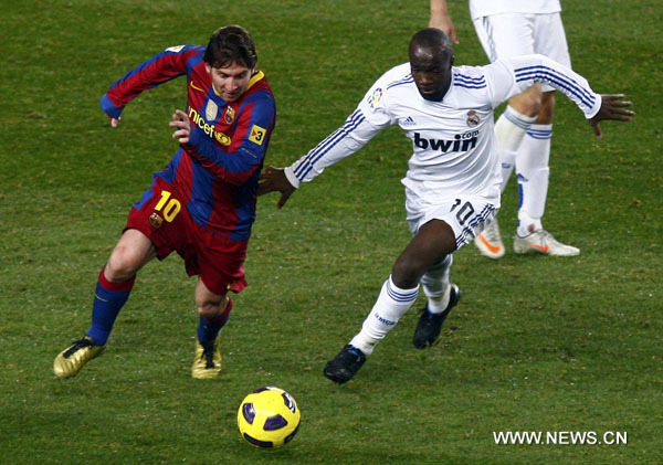 Barcelona's Lionel Messi (L) and Real Madrid's Lassana Diarra battle for the ball during their Spanish first division soccer match at Nou Camp stadium in Barcelona, November 29, 2010. (Xinhua/Reuters Photo)