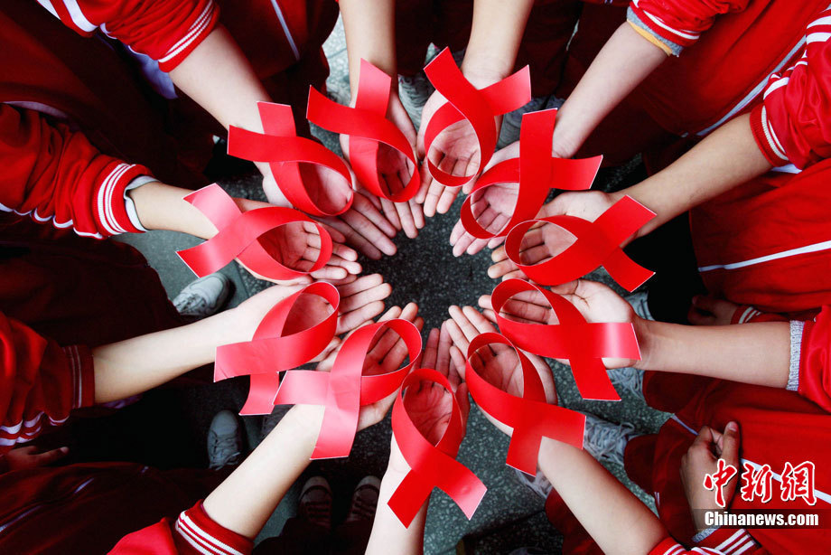 Pupils of Tongkuang No.2 Primary School show their handmade red ribbons during a publicity activity on AIDS prevention in Dexing City of east China&apos;s Jiangxi Province, Nov. 30, 2010, a day ahead of the World AIDS Day. [Xinhua]