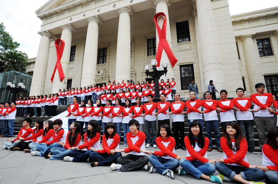 Some 100 &apos;campus ambassadors of AIDS prevention&apos; pose to form the shapes of red ribbons in front of a museum during an activity in Taipei, southeast China&apos;s Taiwan, on Nov. 30, 2010, a day ahead of the World AIDS Day. [Xinhua]