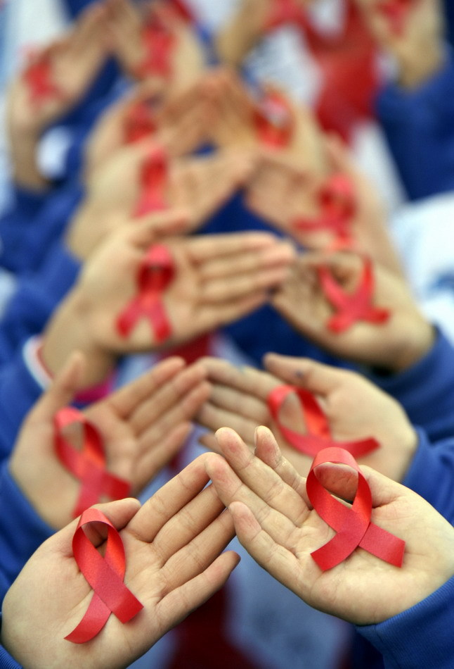 Pupils of Tongkuang No.2 Primary School form the shape of a red ribbon during a publicity activity on AIDS prevention in Dexing City of east China&apos;s Jiangxi Province, Nov. 30, 2010, a day ahead of the World AIDS Day. [Xinhua]