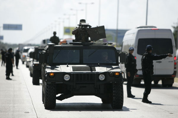 Soldiers lead a convoy of armoured personnel carriers while patrolling the area surrounding the venue of climate talks in Cancun Nov 29, 2010. [China Daily/Agencies]